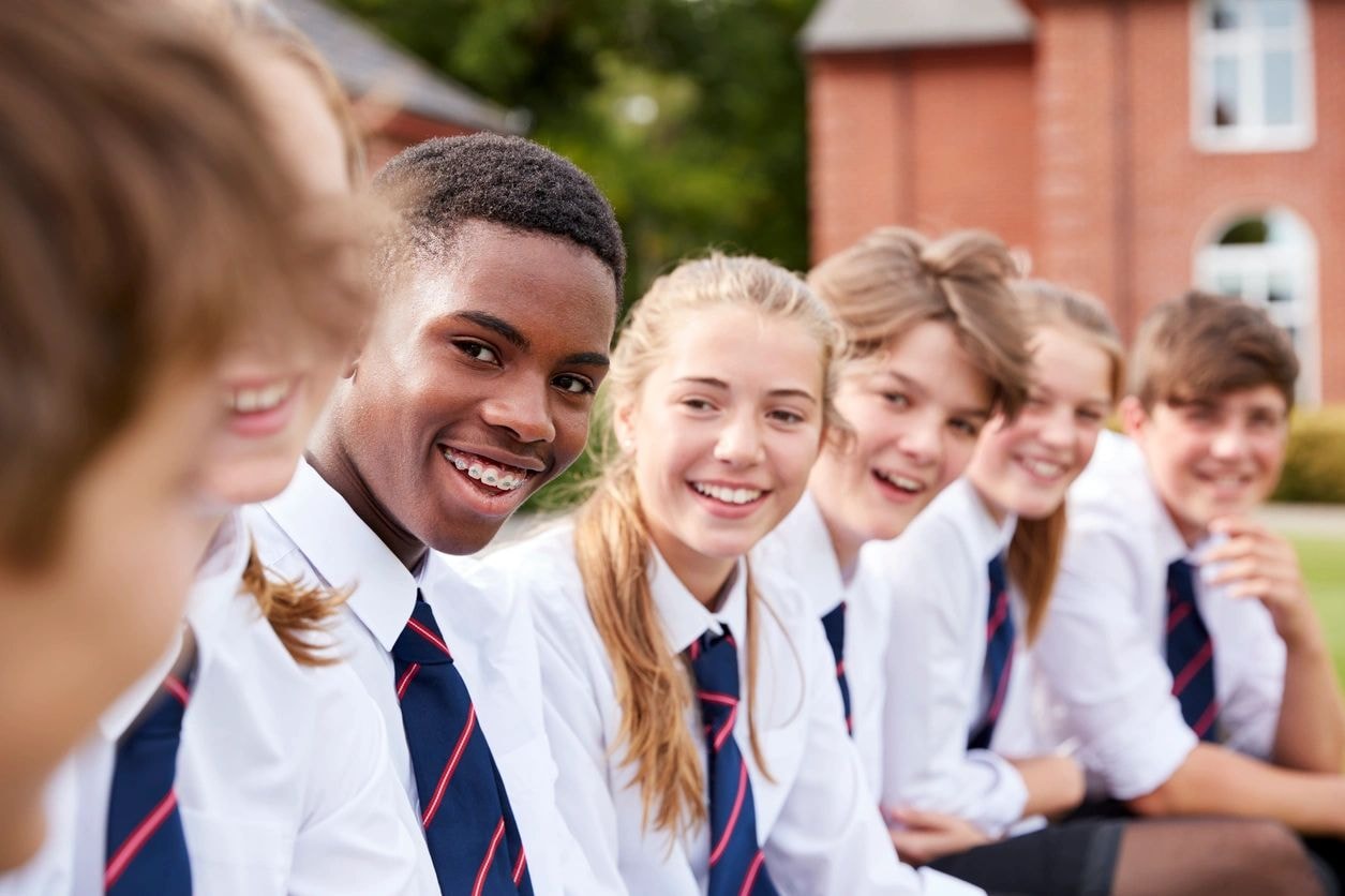 Diverse students in school uniforms smiling together